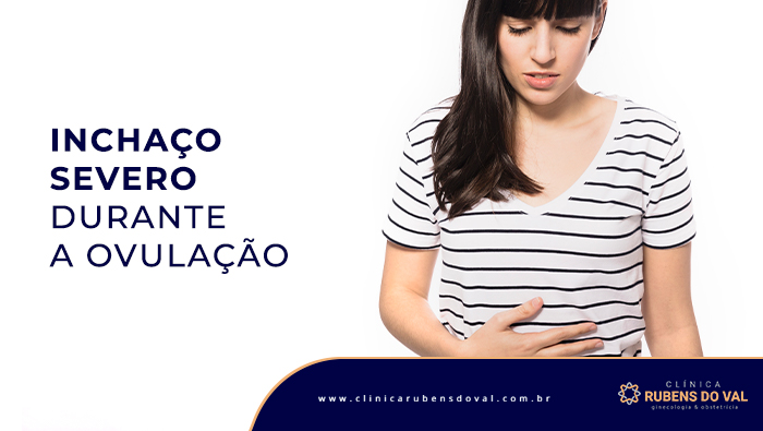 A imagem mostra uma mulher, da cabeça à cintura, com a mão esquerda na barriga, expressando dor em seu rosto.