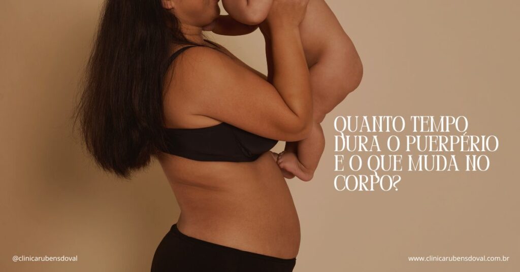 Mulher em roupa íntima preta segura e beija bebê, mostrando corpo pós-parto em ambiente com fundo neutro.